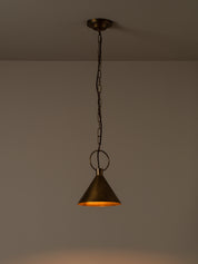 A single hanging pendant light with a dark metal chain and ceiling canopy, featuring a conical shade with a warm brass or bronze interior glowing orange, shown against a plain wall.