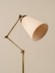 Floor lamp with a white pleated shade on a beige background