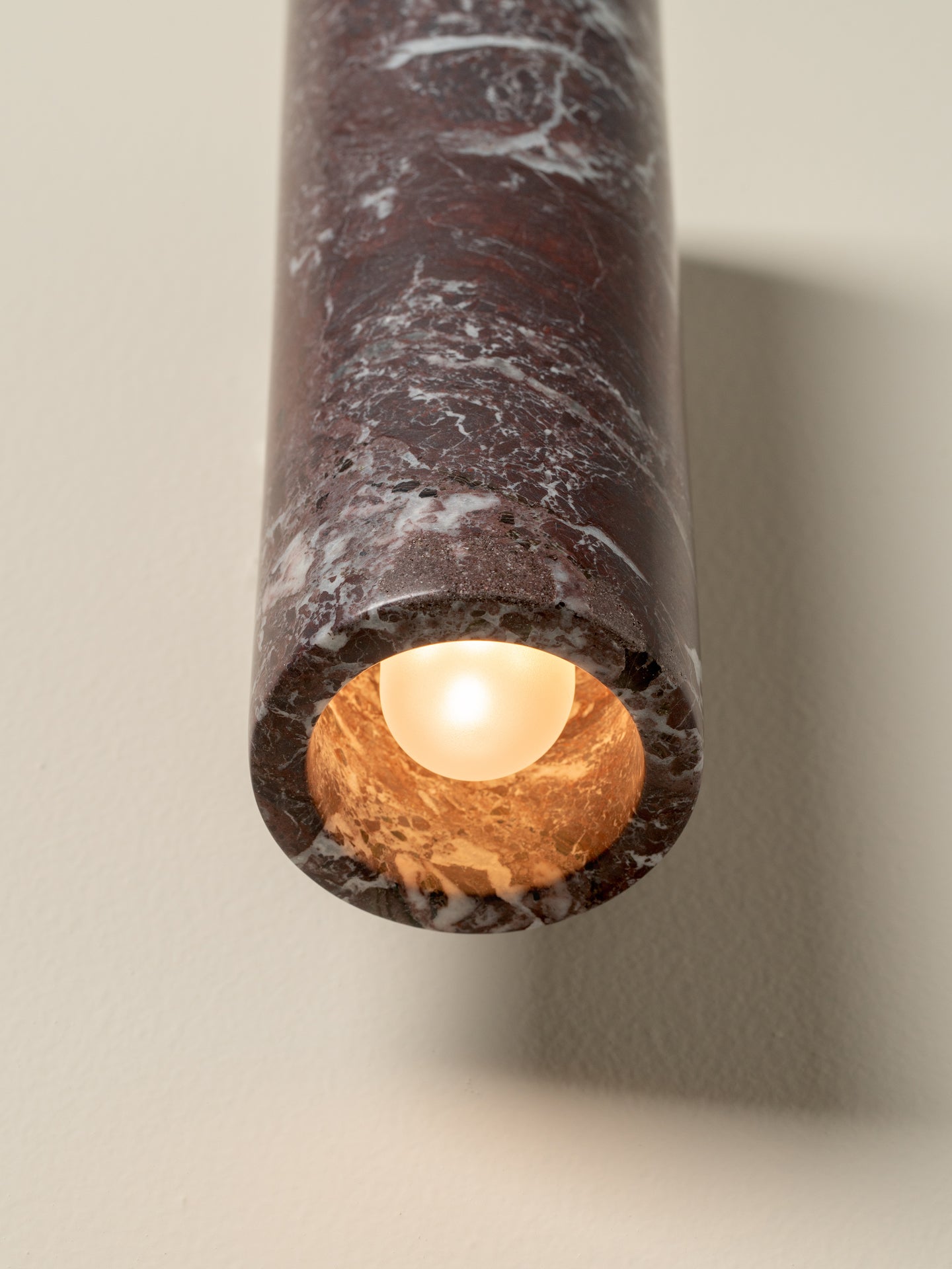Marble-textured cylindrical light fixture on a neutral background