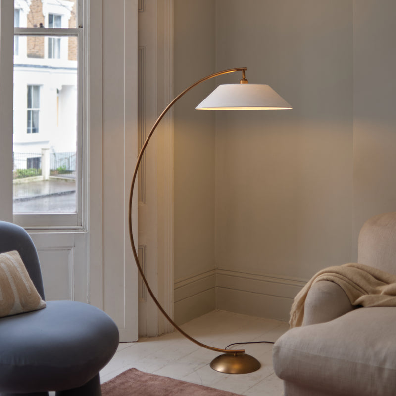 Modern floor lamp in a living room with a window and armchair.