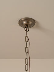 An industrial-style ceiling light fixture canopy with a hanging chain, shown against a plain beige wall and ceiling.