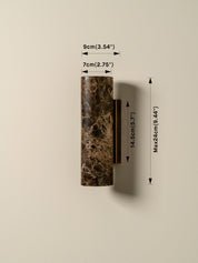 A wall-mounted cylindrical sconce in a dark brown and black marble pattern, shown with dimension lines and text indicating measurements of 9cm width, 7cm depth, and a maximum height of 14.5cm.