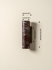 A wall-mounted cylindrical sconce in dark brown marble with white veining, shown with dimension arrows and labels indicating 9cm width, 7cm depth, and a maximum height of 24cm.