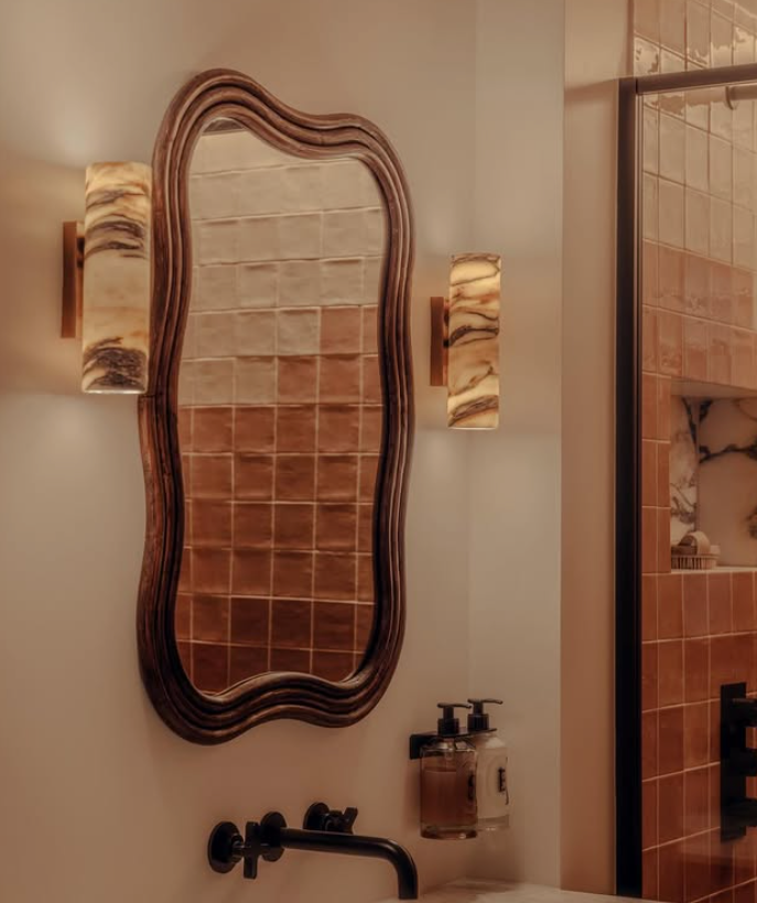 Decorative mirror with wavy frame in a bathroom setting