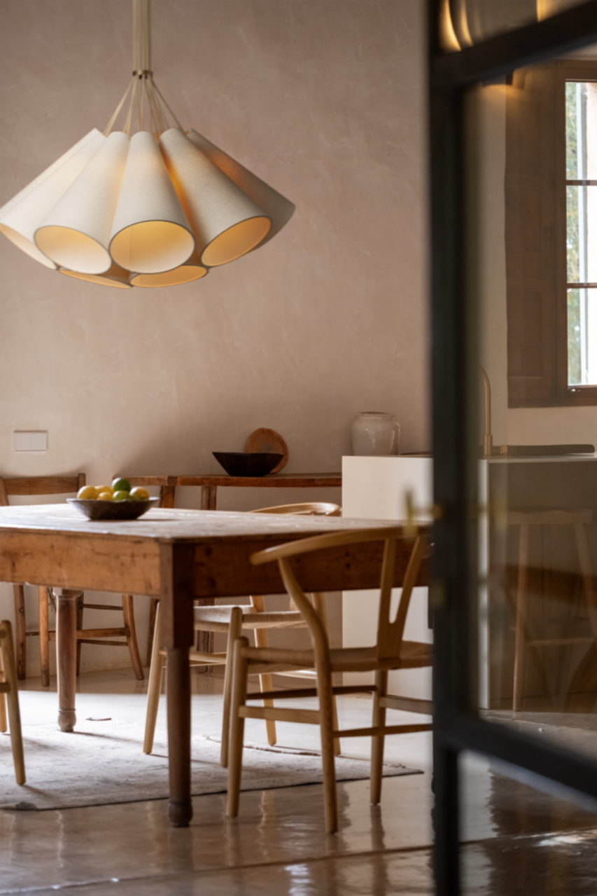 Image of pendant with tube shad features over a dinner table