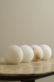 Close-up of a wooden lamp with spherical white shades on a neutral background