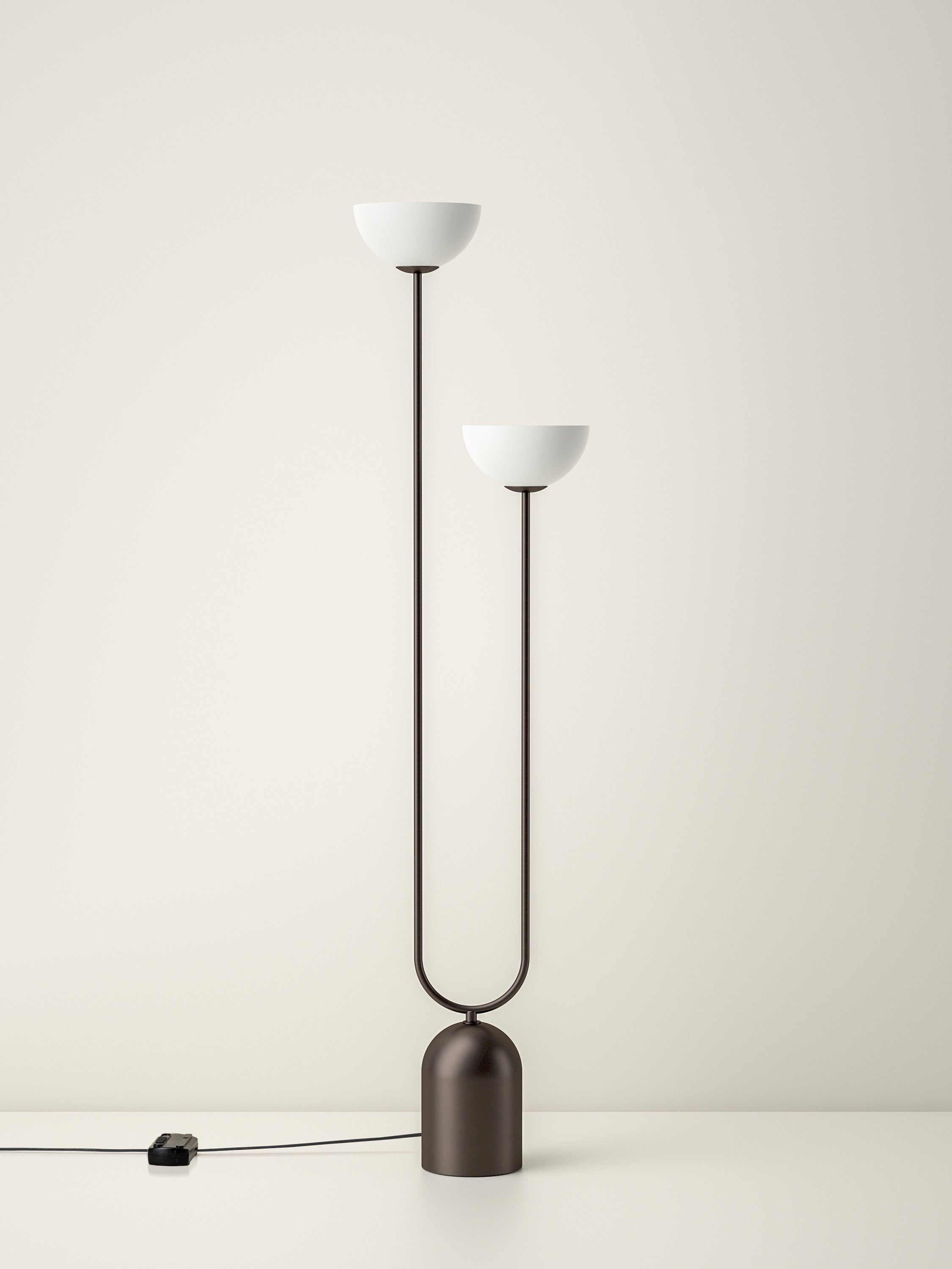 Modern floor lamp with two white lampshades on a plain background